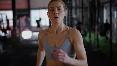 Spor salonunda egzersiz yapan kaslı bir kadın. Atletizm antrenmanı. Güzel vücudunu ve vücut şeklini gösteren güçlü atletik kadın..