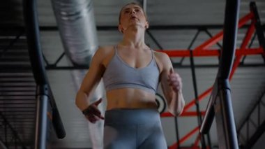 Spor salonunda egzersiz yapan kaslı bir kadın. Atletizm antrenmanı. Güzel vücudunu ve vücut şeklini gösteren güçlü atletik kadın..