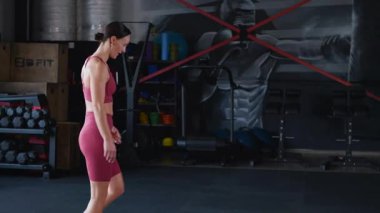 Spor salonunda ip eğitimi alan bir kadın. Kadınlar için ağır ip kaldırma egzersizleri.