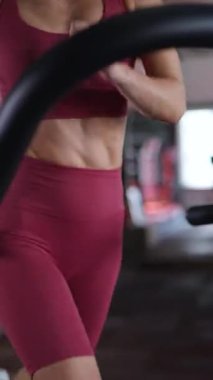 Dikey. Koşu bandında koşan sporcu kadın. Üstte güzel bir atletik figürle koşan bir kadın ve koşu bandında hızlı koşan bir şort..
