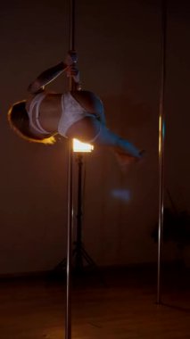 Dikey olarak. Loş stüdyoda, direğin üzerinde büyüleyici bir dans başlıyor. Kadın dansçının silueti direğe karşı. Havada asılı kalmış, zarif bir şekilde direğe tutunan bir dansçı. Egzotik direk
