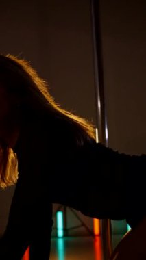 Dikey olarak. Loş stüdyoda, direğin üzerinde büyüleyici bir dans başlıyor. Kadın dansçının silueti direğe karşı. Havada asılı kalmış, zarif bir şekilde direğe tutunan bir dansçı. Egzotik direk