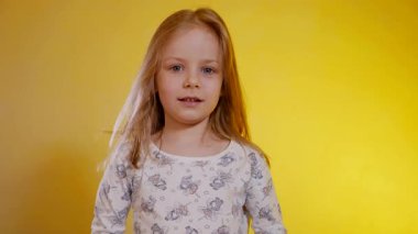 Desenli pijamalı genç kız iki tane turuncu mandalina tutuyor ve onlarla neşeyle oynuyor. Çocuk portakallarla gözlerini kapatıyor, neşeyle gülüyor ve sabah egzersizlerinde tuhaf hareket ediyor..