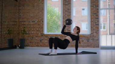 Bir kadın esneme ve pilates yapıyor. Parlak bir stüdyoda esneyen ve dengeyi bulan zarif bir kadın pozu. Gökyüzüne uzanan bir kadın, içindeki gücü yoga akışında bulur. Siyah giysi, odaklanmış ifade