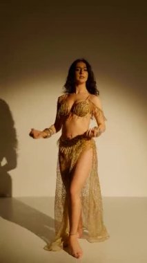 Büyüleyici bir dansçı, altın içinde parıldayan, hareketleri büyüleyici bir manzara. Altın ışık bir dansçının zarif şeklini aydınlatır, göbek dansının sanatını gözler önüne serer..