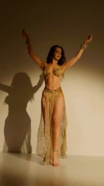 Büyüleyici bir dansçı, altın içinde parıldayan, hareketleri büyüleyici bir manzara. Altın ışık bir dansçının zarif şeklini aydınlatır, göbek dansının sanatını gözler önüne serer..