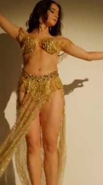 Büyüleyici bir dansçı, altın içinde parıldayan, hareketleri büyüleyici bir manzara. Altın ışık bir dansçının zarif şeklini aydınlatır, göbek dansının sanatını gözler önüne serer..