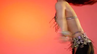 Siyah sutyen ve etekle göbek dansı yapan güzel bir genç kadın. Güzel vücutlu narin bir kız doğu dansları yapar. Doğulu göbek dansı.