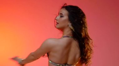 Siyah sutyen ve etekle göbek dansı yapan güzel bir genç kadın. Güzel vücutlu narin bir kız doğu dansları yapar. Doğulu göbek dansı.