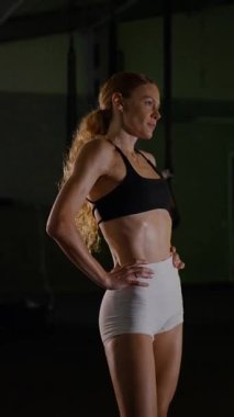 Dikey. Güzel vücutlu bir kadın spor salonundaki ağır egzersizlerden dinleniyor. Güzel genç sporcu egzersizler arasında inanılmaz bir vücut gösterisi sergiliyor..