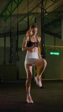 Dikey. Bir kadının güçlü fiziği esneme hareketleri yapıyor. Fitness iş başında. Antrenman devam ediyor. Bir kadının kendini spora adaması, kararlı duruşunda bellidir..