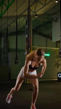Dikey. Bir kadının güçlü fiziği esneme hareketleri yapıyor. Fitness iş başında. Antrenman devam ediyor. Bir kadının kendini spora adaması, kararlı duruşunda bellidir..