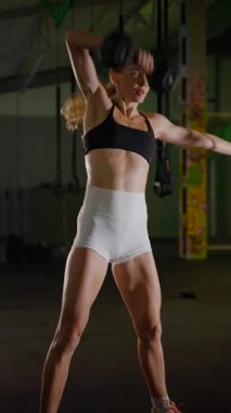 Dikey. Bir kadının güçlü fiziği esneme hareketleri yapıyor. Fitness iş başında. Antrenman devam ediyor. Bir kadının kendini spora adaması, kararlı duruşunda bellidir..