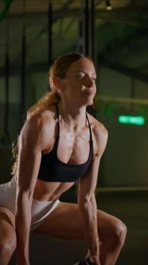 Dikey. Bir kadının güçlü fiziği esneme hareketleri yapıyor. Fitness iş başında. Antrenman devam ediyor. Bir kadının kendini spora adaması, kararlı duruşunda bellidir..