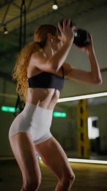 Dikey. Bir kadının güçlü fiziği esneme hareketleri yapıyor. Fitness iş başında. Antrenman devam ediyor. Bir kadının kendini spora adaması, kararlı duruşunda bellidir..