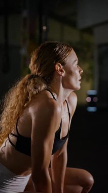 Dikey. Bir kadının güçlü fiziği esneme hareketleri yapıyor. Fitness iş başında. Antrenman devam ediyor. Bir kadının kendini spora adaması, kararlı duruşunda bellidir..