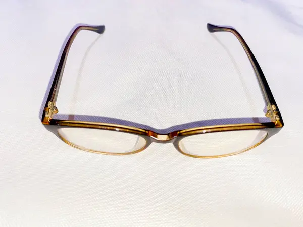 Beyaz arka planda kahverengi gözlükler. Yetişkinler için gözlük.