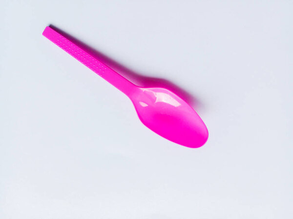 Фиолетовая пластиковая ложка изолирована на белом фоне. Пластиковая ложка для еды.