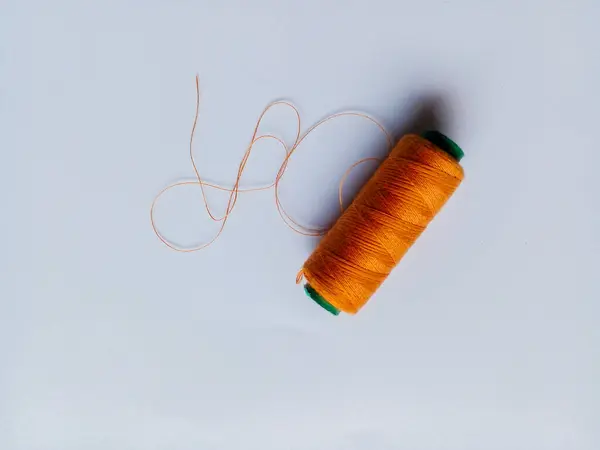 Kahverengi iplik beyaz arka planda izole edilmiş. Dikiş için iplik.