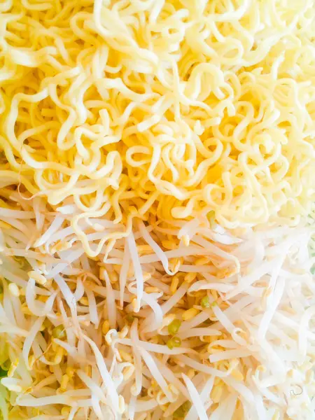 Yeşil tabakta fasulye filizi ve haşlanmış sarı erişte. Lezzetli haşlanmış sarı fasulye filizi ve erişte..