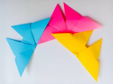 Mavi, pembe ve sarı renkli Origami kuşları. Origami kuşları beyaz arkaplanda izole edilmiş.