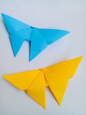 Origami kuşu mavi ve sarı. Origami kuşları beyaz arkaplanda izole edilmiş.