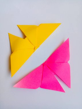 Sarı ve pembe renkli Origami kuşları. Origami kuşları beyaz arkaplanda izole edilmiş.