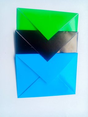 Beyaz arkaplan üzerinde mavi, siyah ve yeşil zarflar..