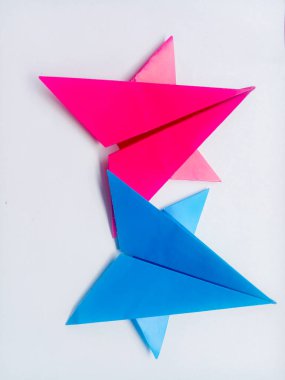 Pembe ve mavi kağıt yıldız origamisi boş beyaz bir arkaplanda izole edilmiştir.