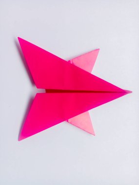 Pembe kağıt yıldız origamisi boş beyaz bir arkaplanda izole edildi.