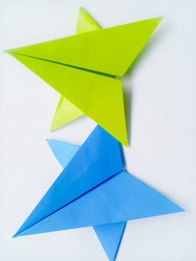 Mavi ve yeşil kağıt yıldız origamisi boş beyaz bir arkaplanda izole edilmiştir.