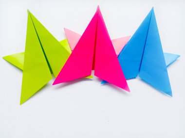 Yeşil, pembe ve mavi kağıt yıldız origami boş beyaz bir arkaplanda izole.