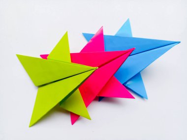 Yeşil, pembe ve mavi kağıt yıldız origami boş beyaz bir arkaplanda izole.