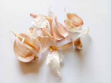 Soyulmuş sarımsak derisi beyaz arkaplanda izole edilmiş..