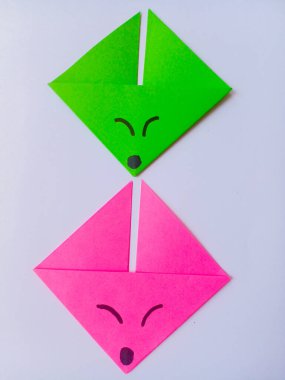 Origami yeşil ve pembe tilki kafası beyaz arkaplanda izole edilmiş..