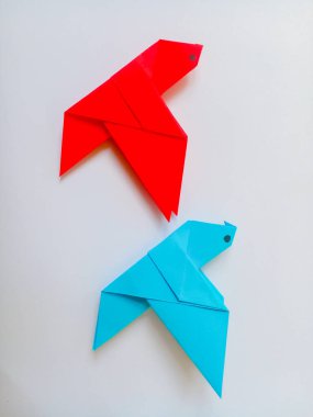 Origami kırmızı ve mavi kuşlar beyaz zemin üzerinde izole.