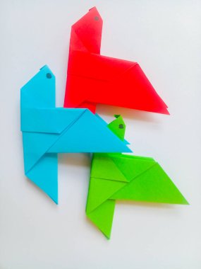 Origami mavi, kırmızı ve yeşil kuşlar beyaz zemin üzerinde izole.