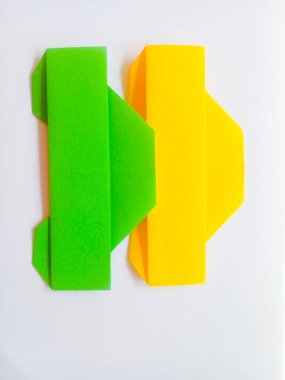 Origami yeşil ve sarı arabalar beyaz arkaplanda izole edilmiş..