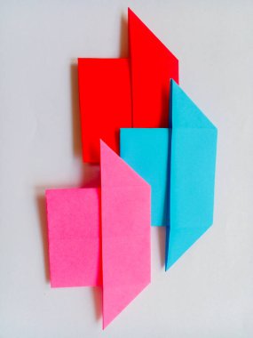 Beyaz arkaplanda pembe, mavi ve kırmızı origami izole edilmiş..