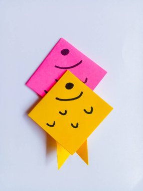 Beyaz arkaplanda pembe ve sarı balık origamisi izole edilmiş..