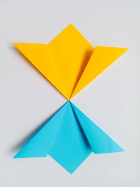 Origami sarı ve mavi çiçekleri beyaz arkaplanda izole edilmiş.