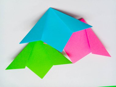 Origami yeşil, mavi ve pembe çiçekler beyaz arkaplanda izole edilmiş.