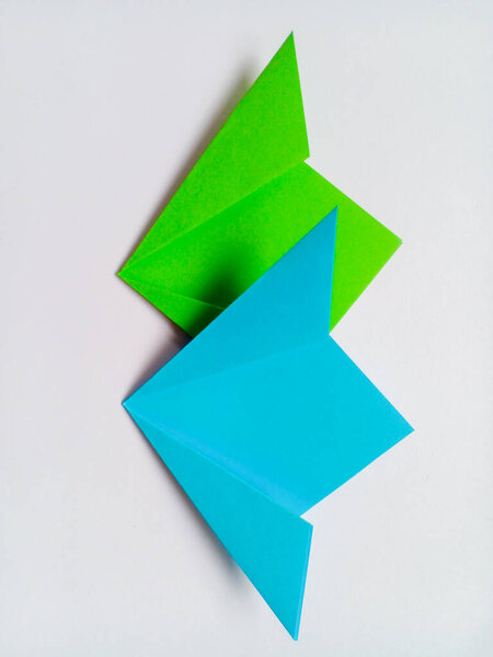 Оригами зеленые и синие цветы изолированы на белом фоне.