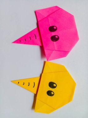 Origami pembe ve sarı fil kafası beyaz arkaplanda izole edilmiş..