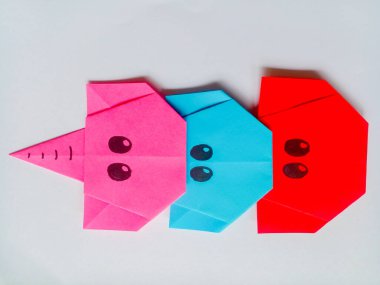 Origami pembe, mavi ve kırmızı fil kafası beyaz arkaplanda izole edilmiş..