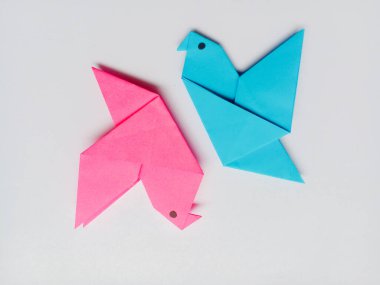 Pembe ve mavi kuş origamisi beyaz arkaplanda izole edildi.