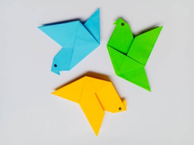 Beyaz arkaplanda mavi, sarı ve yeşil origami izole edilmiş..