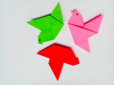 Beyaz arkaplanda yeşil, kırmızı ve pembe origami izole edilmiş.