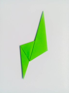 Beyaz arkaplanda yeşil yıldırım origamisi izole edildi.