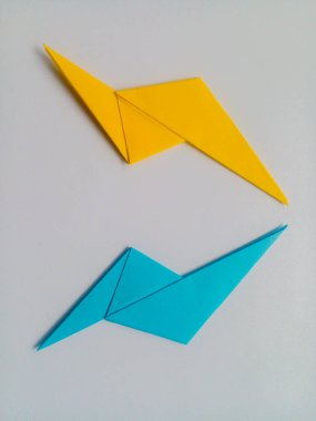 Sarı ve mavi yıldırım origamisi beyaz arkaplanda izole edildi.